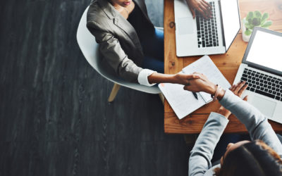 High angle shot of two businesswomen shaking hands in an office